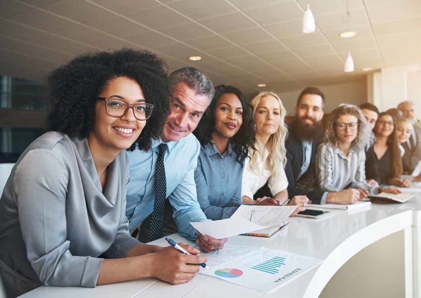 A diverse group of business-people smile at the viewer