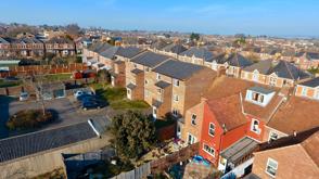 A bird's-eye view of a typical UK housing estate. There looks to be a mixture of flats, terraced houses, and semi-detached houses.